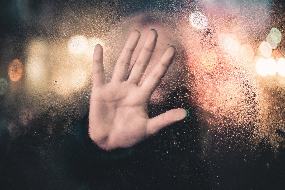 Hand auf Glasscheibe
