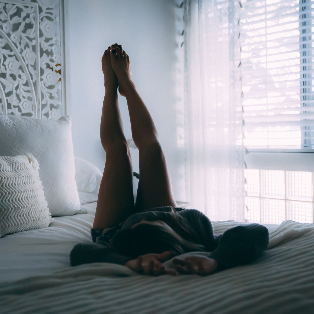 Mädchen im Bett mit angehobenen Beinen