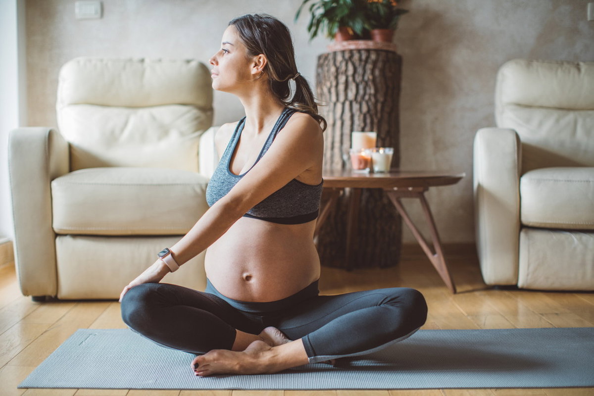 Schwangere Frau auf Fitnessmatte