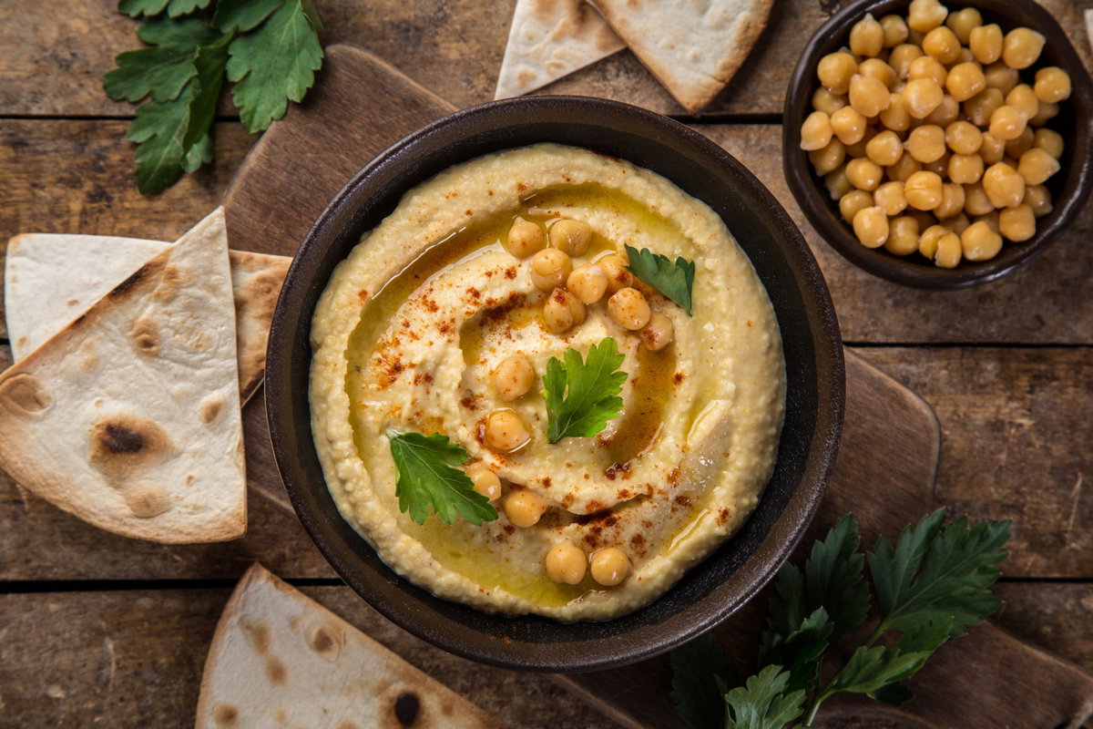 Schüssel mit Hummus und Kichererbsen