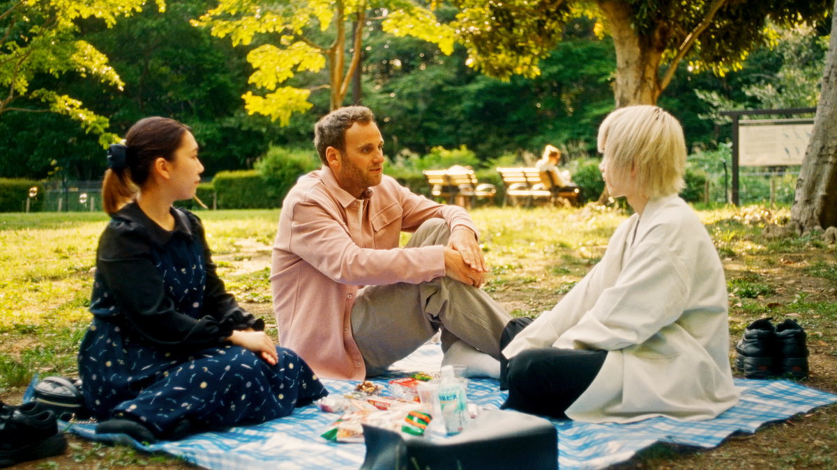 "Terra X: Liebe - Wie sie kommt": Leon sitzt mit zwei Japanern im Park auf einer Wiese.