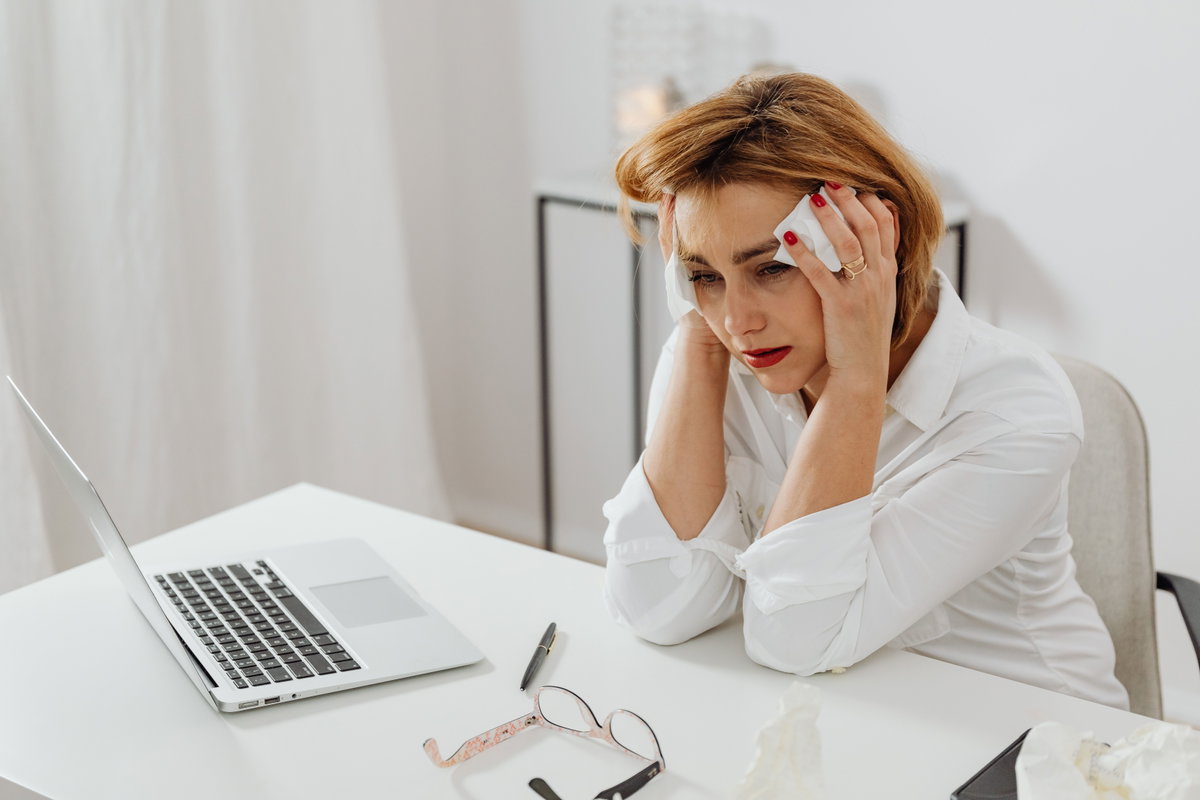 Frau in der Menopause schwitzt im Büro