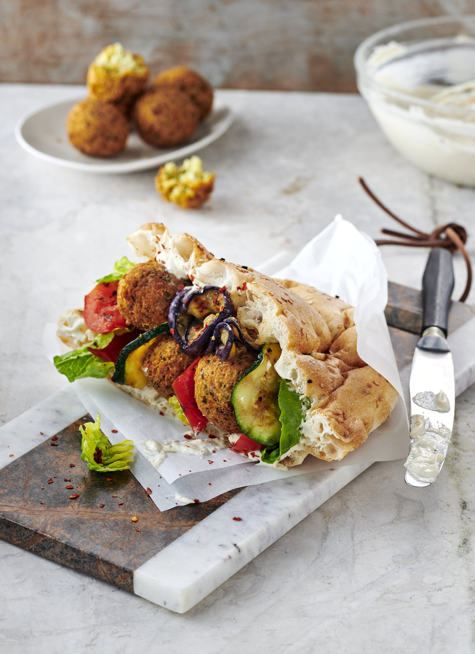 Genialer Streetfood-Klassiker: Knuspriges Falafel-Sandwich mit gegrilltem Gemüse und cremiger Sesamsauce